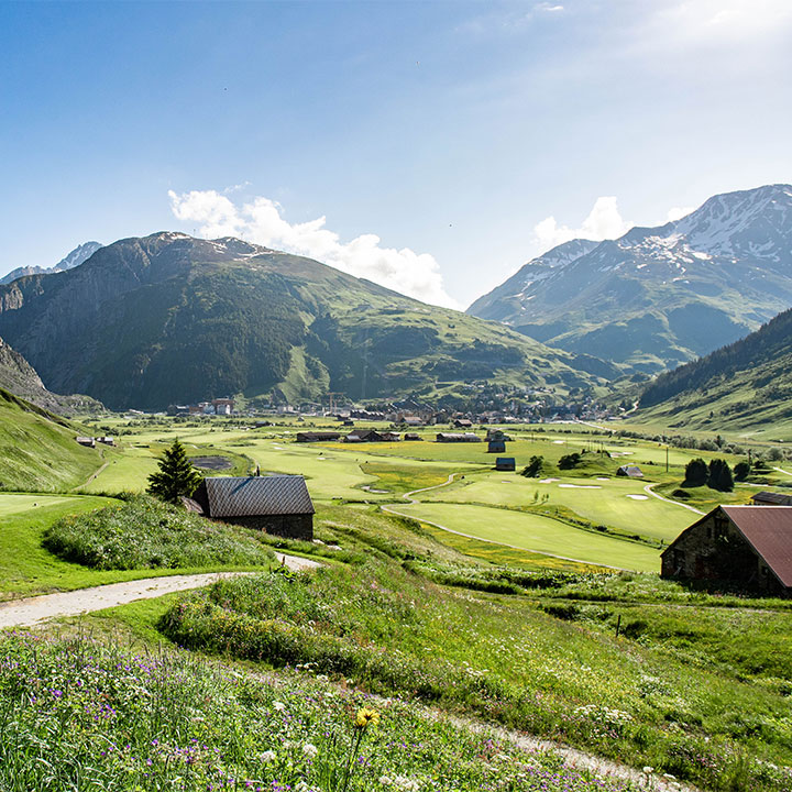 Andermatt Swiss Alps Golf Course fairways on the valley floor beneath the peaks of the canton of Uri, Switzerland