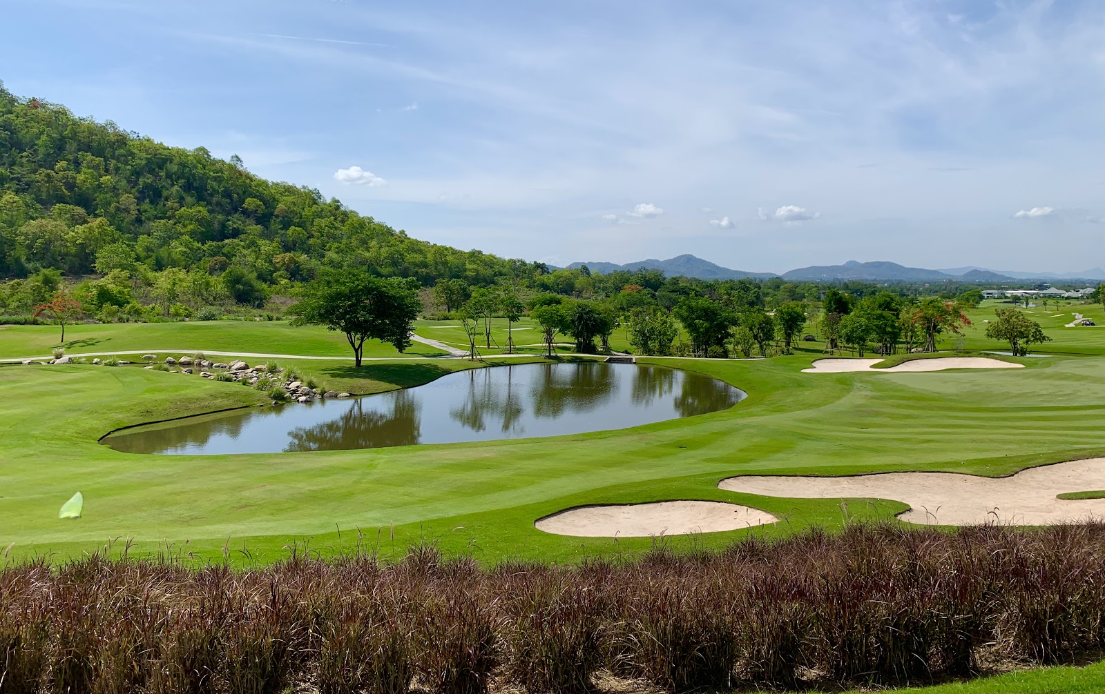 Hua Hin golf, fairways set against dark foothills near the Gulf of Thailand